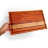 C03-3 Hand holding handcrafted edge-grain cutting board with oak and walnut accent stripes and juice groove, made by Hunarmand786.