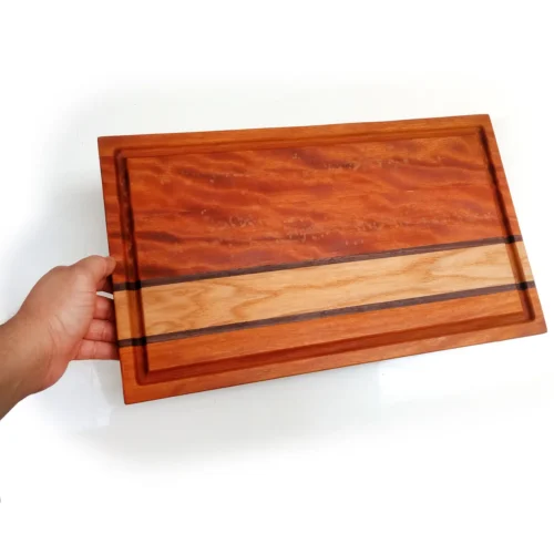 C03-3 Hand holding handcrafted edge-grain cutting board with oak and walnut accent stripes and juice groove, made by Hunarmand786.